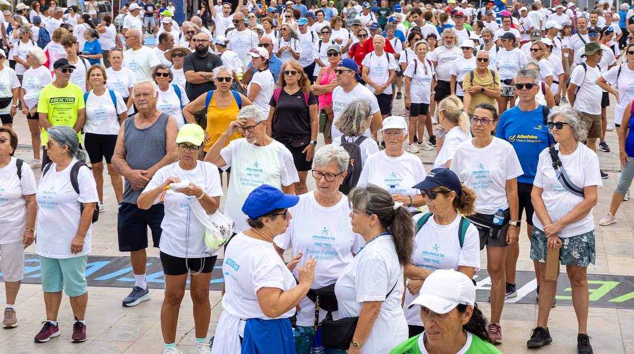 A group fitness class in full swing at Praça dos Pescadores with participants exercising on mats.